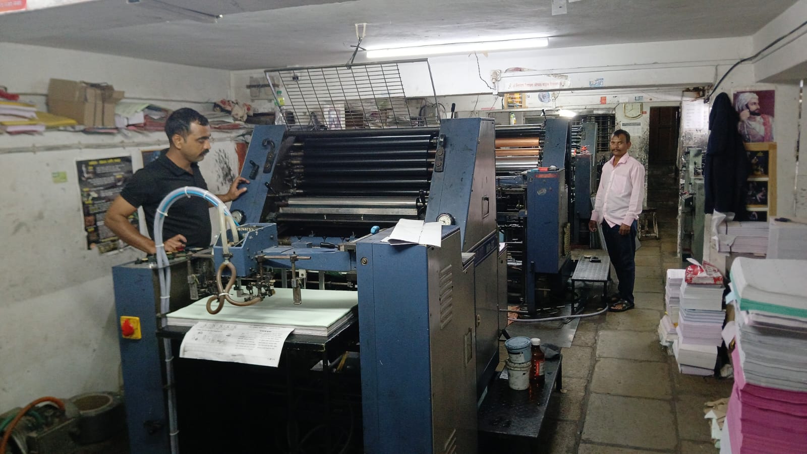 Operators at a sheet-fed offset press on the floor at Lokmangal Mudranalay, Kolhapur.