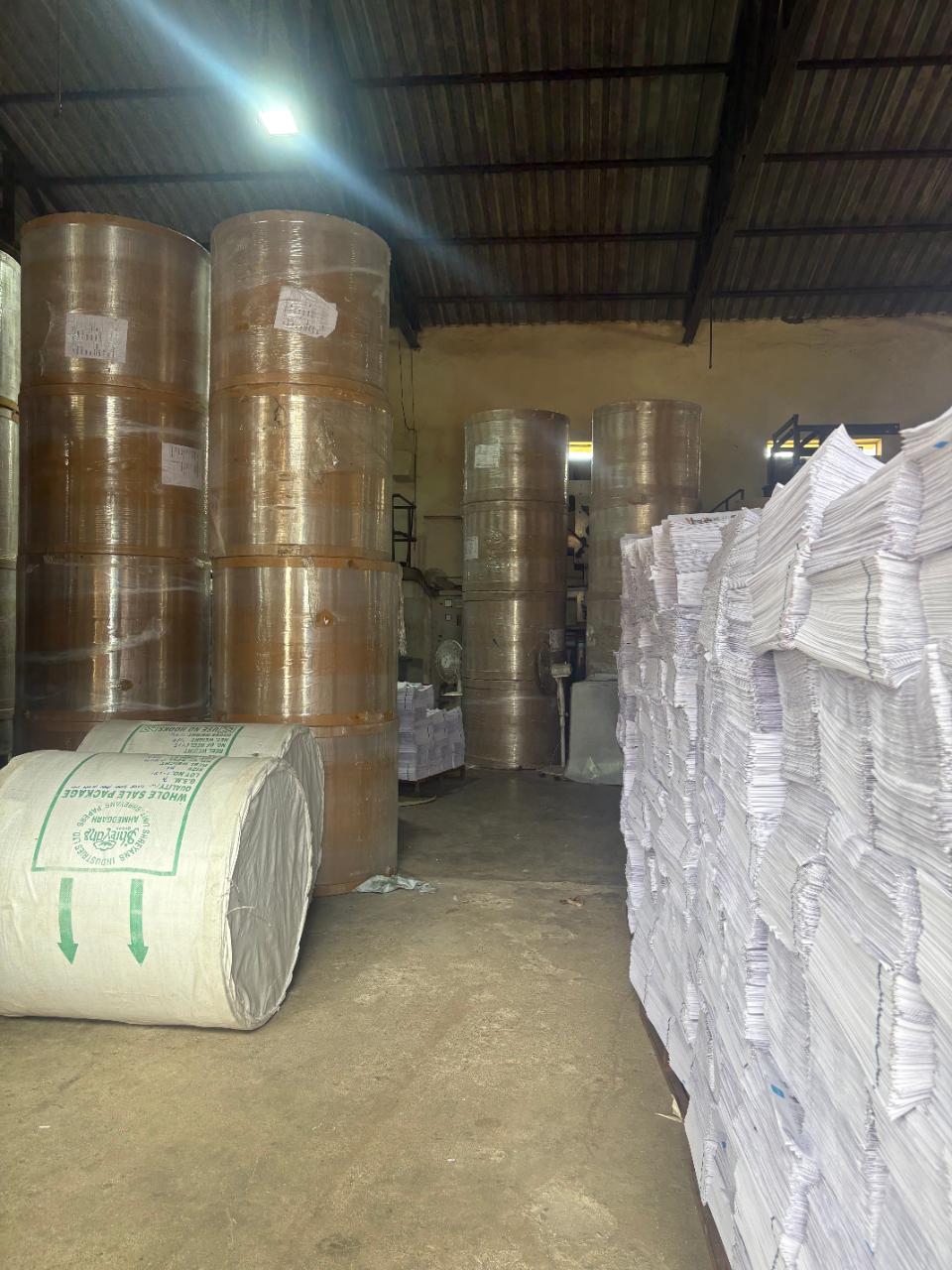 Reels of Shreyans paper and stacks of printed sections in the paper store.