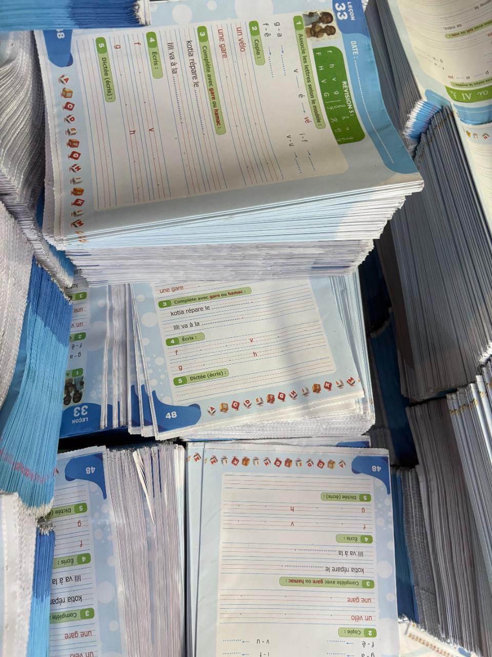 Stacks of French-language educational workbooks printed for the West-African market.