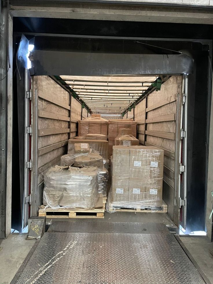Palletised, shrink-wrapped books loaded into a container at the despatch bay.
